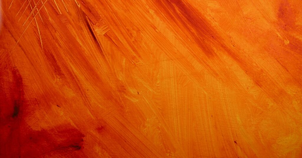 Close-up of an abstract painting with vibrant orange and yellow hues.